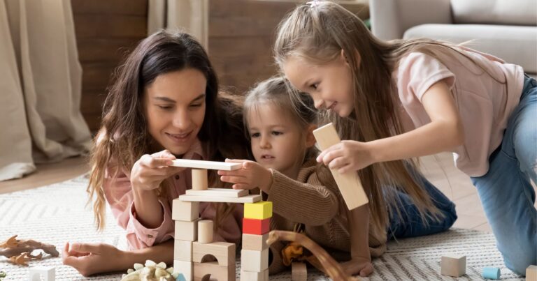 Engaging nanny in the Denver-metro area playing with and engaging her nanny children. This family lives in Parker. They are playing with blocks to focus on ECE activities.