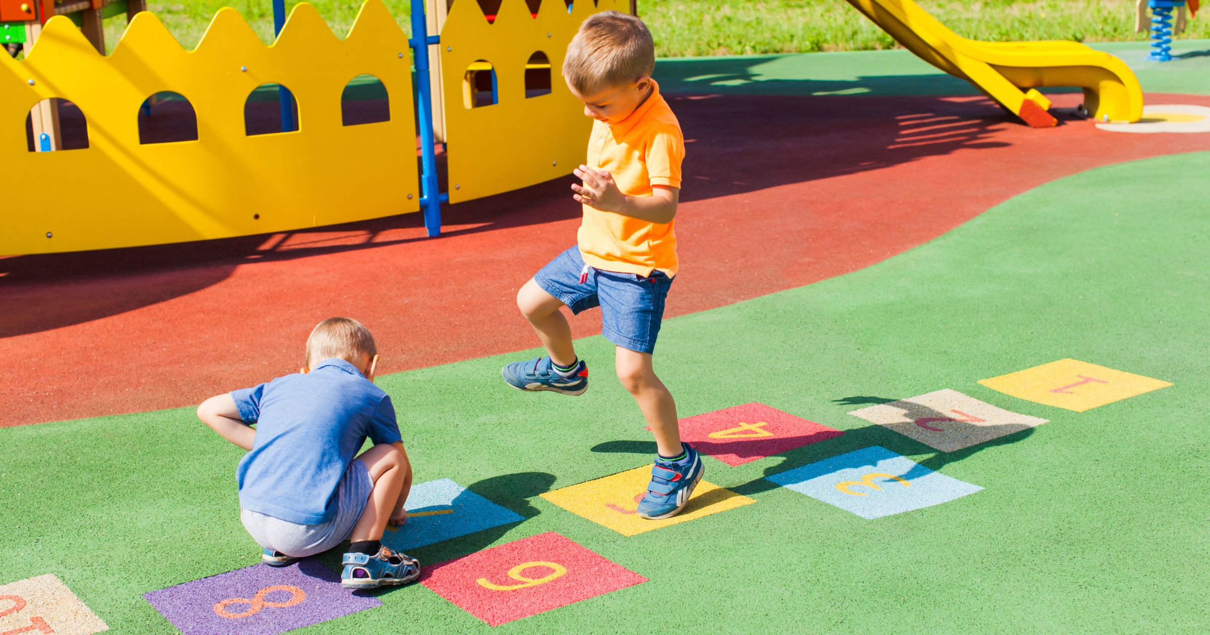 Summer nanny in Denver or Boulder needed for two children with close to full-time hours - children playing hopscotch on brightly colored playground