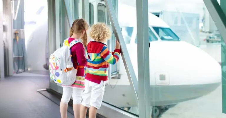 Nanny kids wait by window, watching the plane and wait for their travel nanny to help them on.