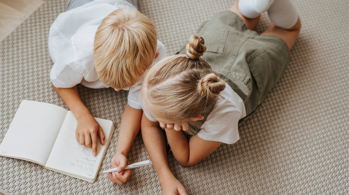 Two children on the floor coloring