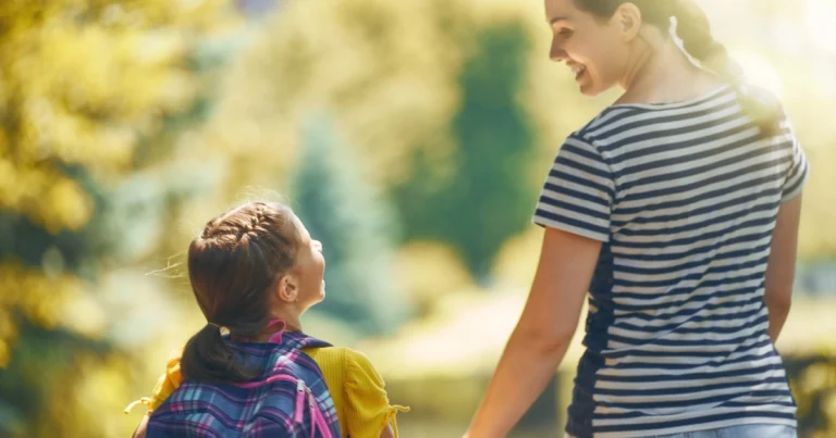 A nanny and child walking to school along a sunny street